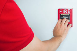 man-is-reaching-his-hand-push-fire-alarm-hand-station-(1)